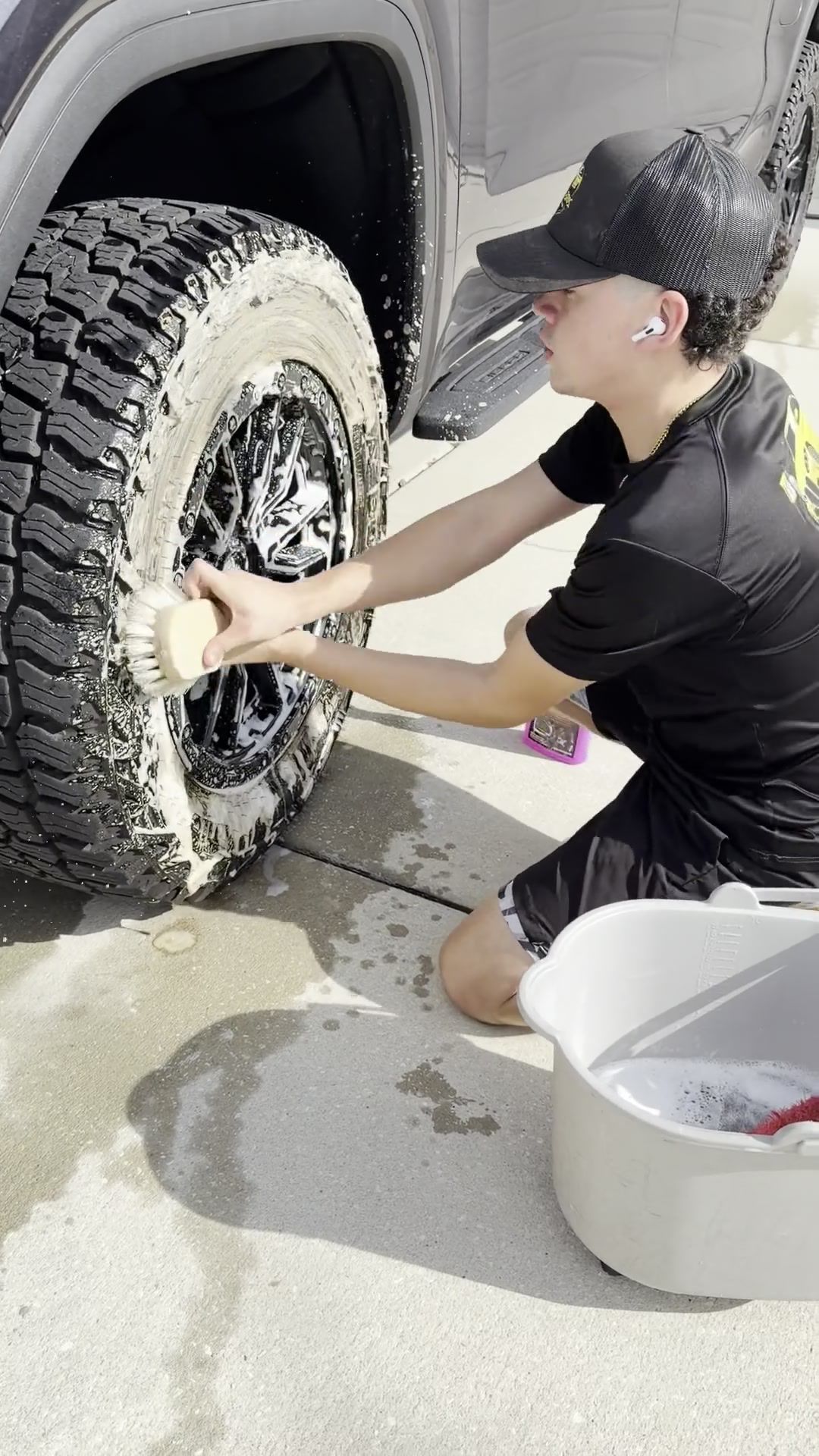 A truck tire being scrubbed during a mobile detail